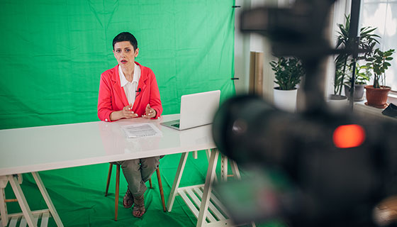 Reporter in front of green screen from the camera‘s view